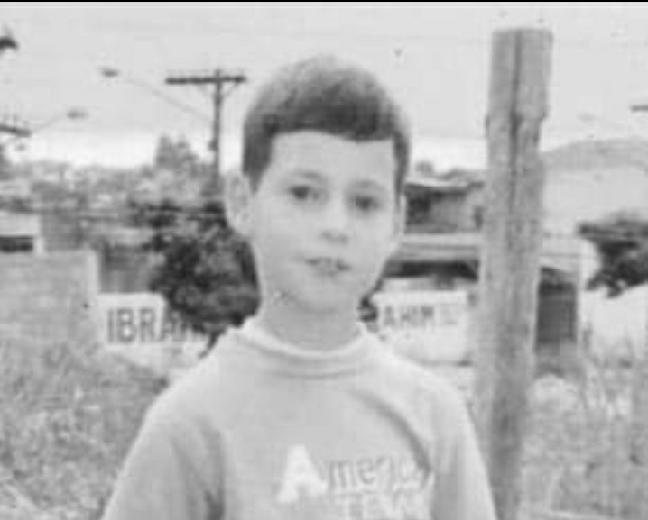 O jovem Marcelo de Lima, quando criança, próximo de uma cerca. 